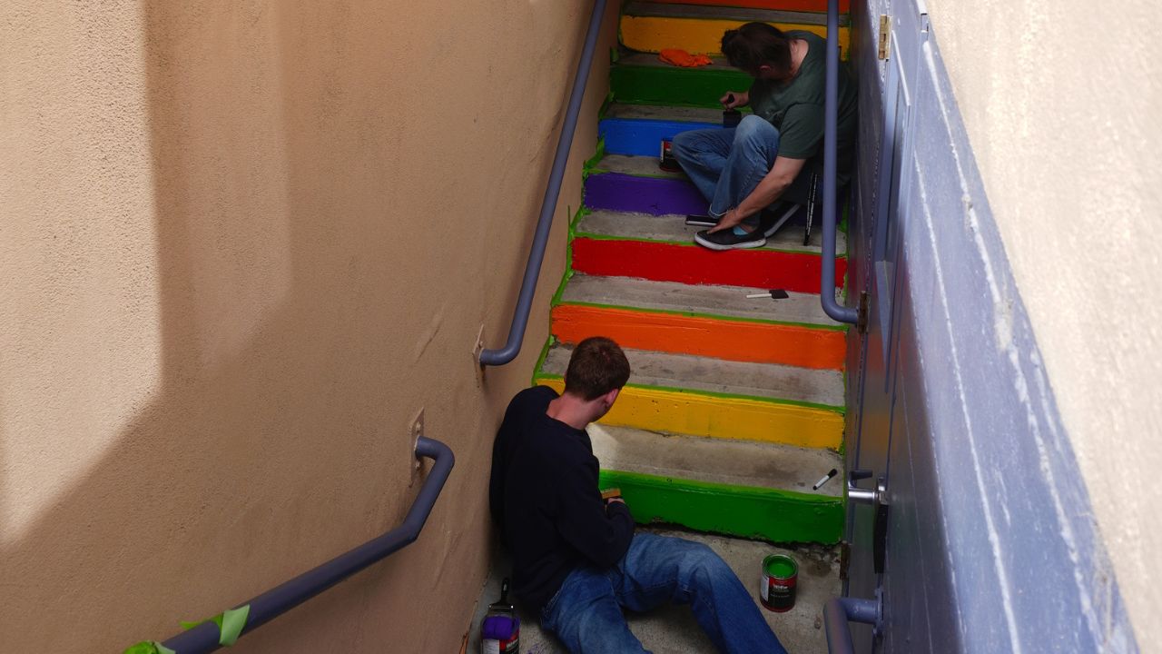 WVC Omak students painting a rainbow on some outdoor stairs