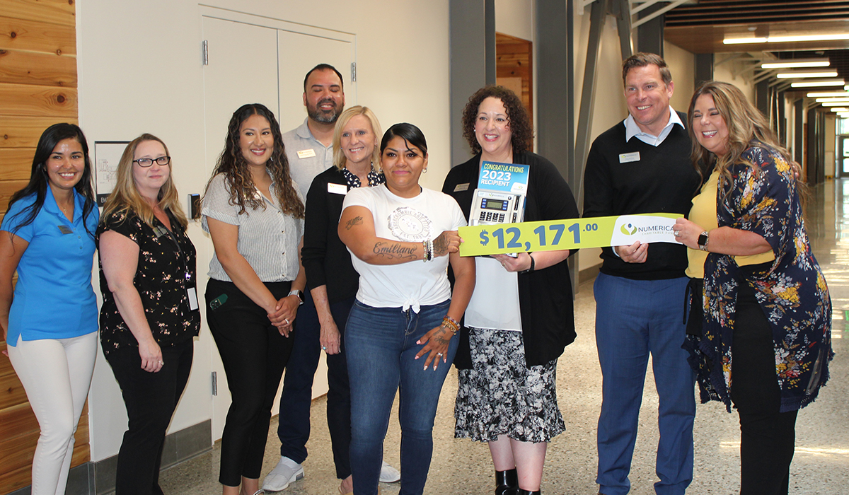 Numerica giving donation with a group of people