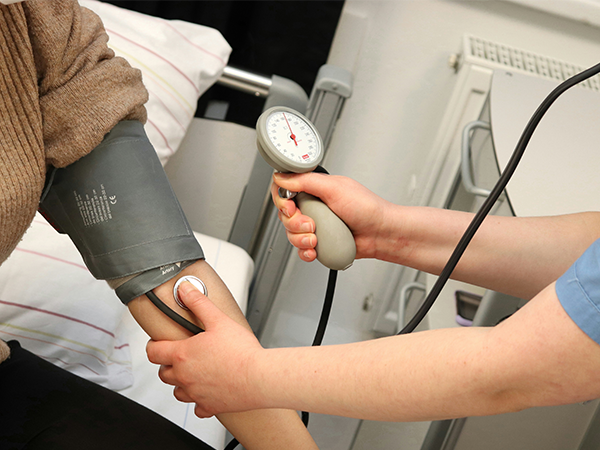 A medical assistant takes a patient's blood pressure.